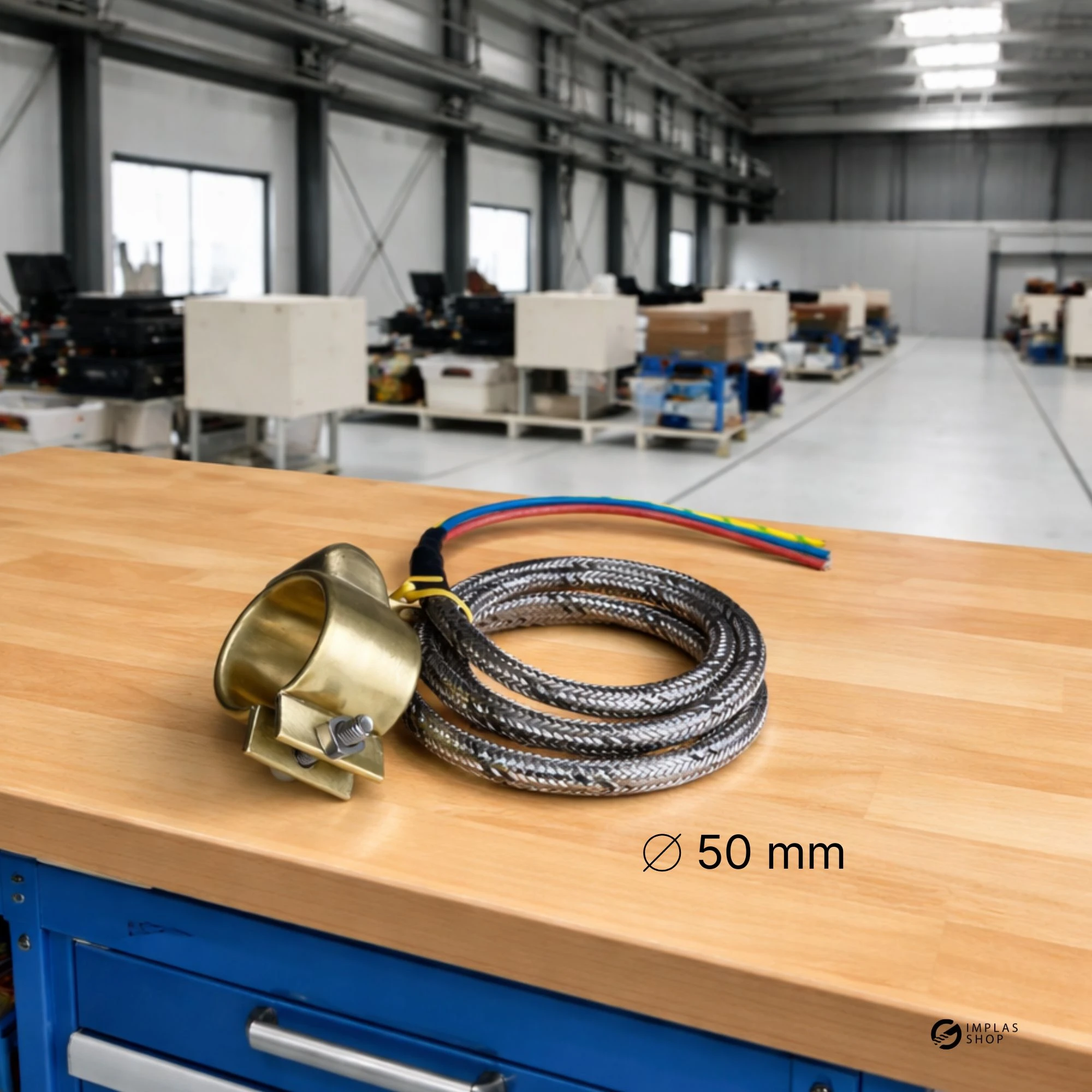 Düsenheizband mit einem Durchmesser von 50 mm für Spritzgussmaschinen auf einer Werkbank in einer Industriehalle. Bild KI-generiert